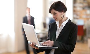 En kvinde, der holder en bærbar computer