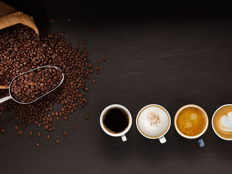 Kaffemaskine-guide: Kaffebønner og kaffekopper set ovenfra