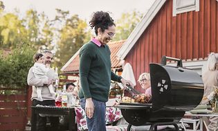 Kvinde stående ved siden af grillen