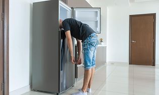 SDA-Cooling-Man sætter hovedet i et køleskab, fryser-min