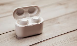 Hvide, trådløse hovedtelefoner i ladeetui