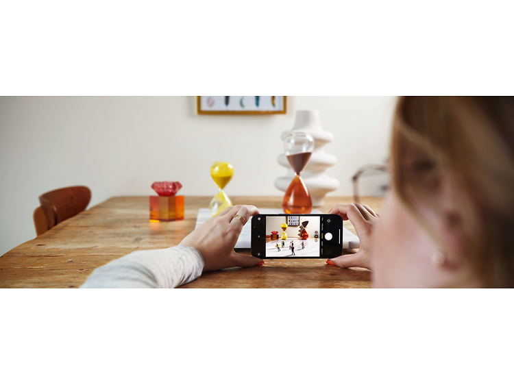 Woman taking a photo of items on a table with her iPhone