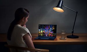 ZenBook 14 OLED - Kvinde, der bruger den på et bord