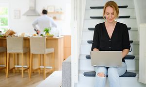 Kvinde, der sidder med sin bærbare computer derhjemme på en trappe