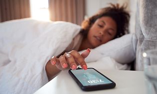 Få din gode døgnrytme tilbage: En kvinde slukker for din alarm på telefonen