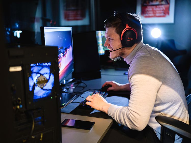 Mand, der spiller på gaming-PC, og som har et HyperX gaming-headset på hovedet