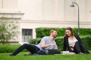 Mand og kvinde med laptop i en park