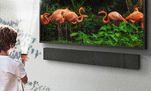 Barn med vandslange nær et Samsung-TV