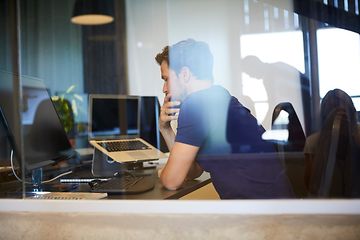 Mand sidder ved et skrivebord og arbejder på et kontor