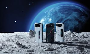 Tre forskellige ROG-telefoner står på en stenet overflade i rummet med en planet i baggrunden