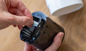 Hånd indsætter sim-kort i et Arlo Go V2 overvågningskamera