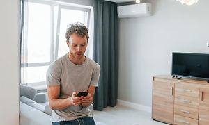 Ung mand styrer intelligent belysning via en app på sin telefon