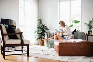 Kvinde og baby sidder på en sofa i stuen