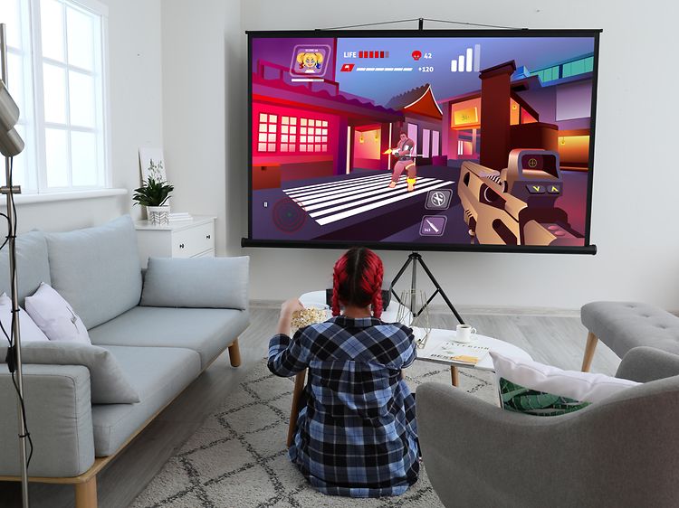 TV - Kvinde, der spiller spil på et stort TV