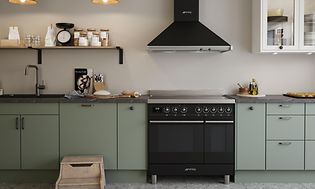 Grønt EPOQ Trend-køkken med sort bordplade og håndvask, med hvidevarer og svævehylder med opbevaring i en åben køkkenløsning