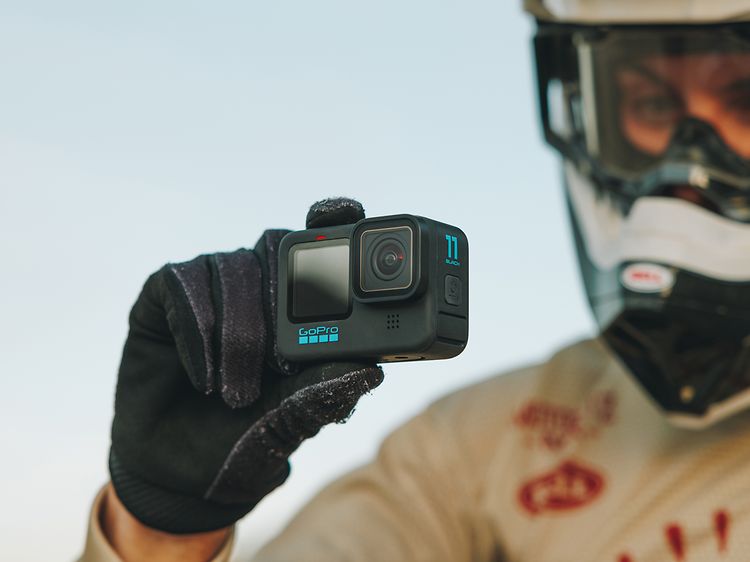 En racerkører holder GoPro HERO11 Black