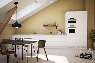 Hvidt EPOQ Integra-køkken med hvid borplade, køkkenvask og hvidevarer i et åbent køkkenmiljø med spisebord, stole og legetøj