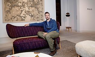 B2B - Mazo - Ejeren af Mazo i en designsofa foran logoet
