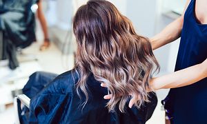 Kvinde med farvet krøllet hår i frisørsalon