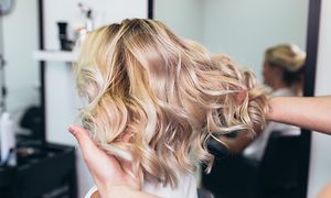 Kvinde med lyst krøllet hår i frisørsalon