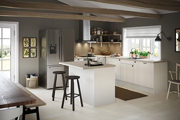 Klassisk hvidt EPOQ Shaker-køkken med grå bordplader, køkkenø og køle- og fryseskab i et åbent køkkenmiljø