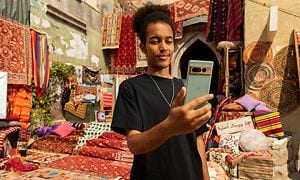 Mand, der står på et marokkansk tæppemarked og ser på sin Google Pixel 7 Pro