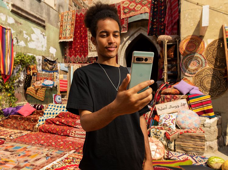 Mand, der står på et marokkansk tæppemarked og ser på sin Google Pixel 7 Pro
