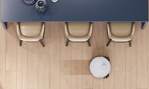 Billede af N8 PRO som mopper et trægulv rund om et bord og stole 