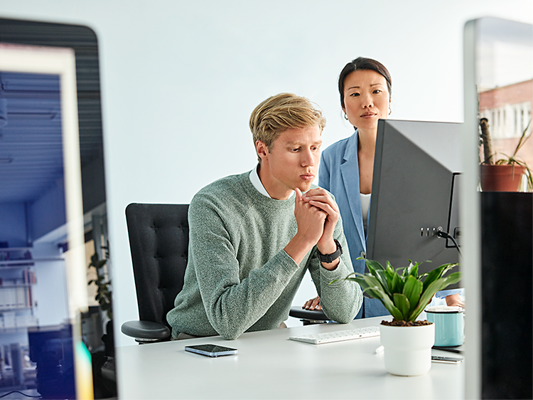 To kolleger på et kontor foran en pc