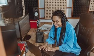 Kvinde i gang med at mixe musik med studie-høretelefoner på
