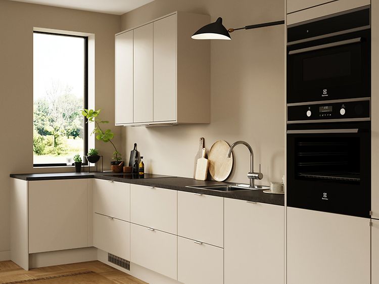 Hvidt EPOQ-køkken med sort bordplade, vask, hvidevarer og overskabe i en åben køkkenløsning