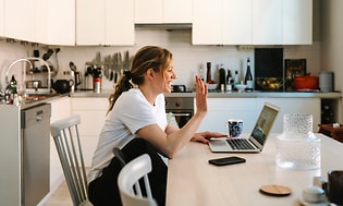 B2B - Gør dit hjemmekontor mere effektivt - En smilende kvinde under et liveopkald på sin bærbare computer