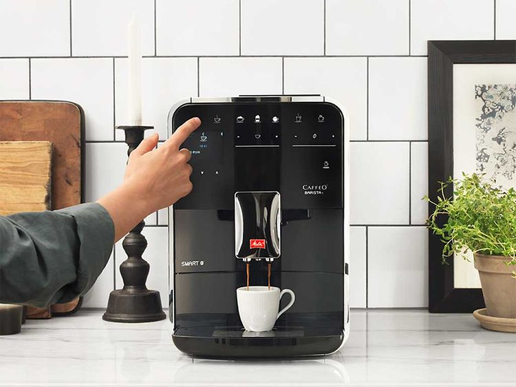 En kvinde bruger Melitta Barista T espressomaskine