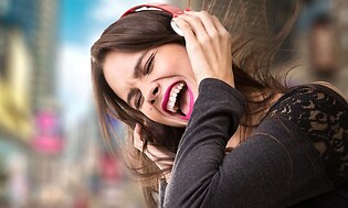 en kvinde i bymiljø bruger støjreducerende hovedtelefoner