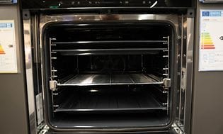 Interiøret af en ren ovn med rene bageplader og riste