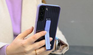 Billede af en kvinde der holder en Samsung-telefon med cover på