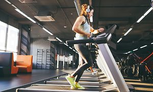 Telecom - Wearables - Woman checking her watch on a treadmill