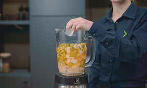 SDA - Blender - En kvinde der tilføjer isterninger til en fyldt blender