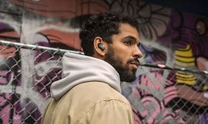Mand iført en hoodie med Bose Earbuds i ørerne