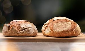 To friskbagte brød på et skærebræt