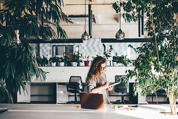 Kvinde der arbejder på et kontor omgivet af planter