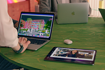 Elkjøp B2B - Vores varemærker - Kontormedarbejdere med deres Apple-produkter på et bord