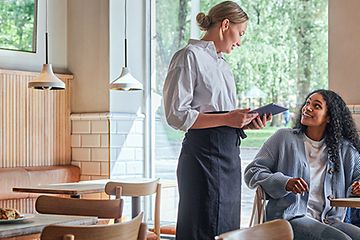 Elkjøp B2B Hospitality - En servitrice tager imod en ordre fra en gæst på en café
