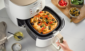 Hvid Philips Airfryer XXL og mad, der tilberedes på dens bageplade