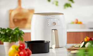 Hvid Philips Airfryer XXL og friske grøntsager og basilikum ved siden af