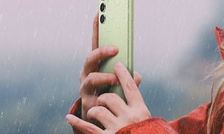 Kvinde med en lysegrøn Galaxy A54 5G i regn