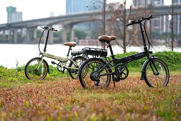 Picture of two electric bikes on a field in a city