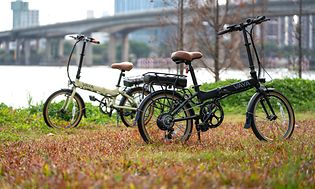 Picture of two electric bikes on a field in a city