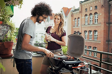 Par der står og griller ude på en altan 