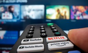 Fjernbetjening med Netflix -, Youtube- og Amazonknapper, peget mod et tv